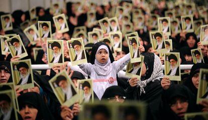 Mujeres iraníes, y entre ellas una niña, sostienen retratos del ayatolá Ali Jamenei durante una reunión en Teherán.