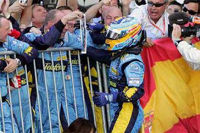 Fernando Alonso celebra la victoria con sus mecánicos.
