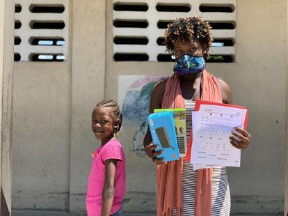 En la fotografía, una madre y su hija de Puerto Príncipe (Haití) posan con el material escolar con el que seguirán la educación en sus casas. Imagen de archivo, de abril de 2020.