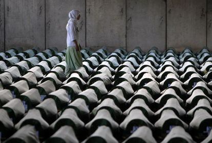 Una mujer bosnia camina entre los féretros de las 409 víctimas identificadas de la matanza musulmana en Srebrenica en el centro memorial de Potocari.