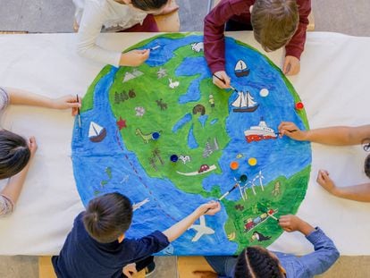 Unos niños dibujan la Tierra en clase