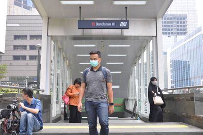 Un hombre con mascarilla sale del metro en Yakarta.
