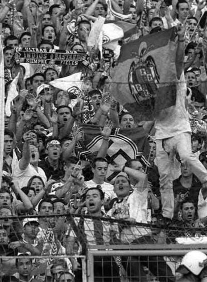 Seguidores <i>ultras</i> del Madrid muestran sus símbolos durante un partido contra el Atlético en 1997.