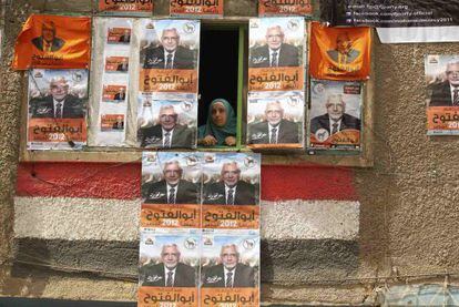 Una mujer asomada a una ventana rodeada de carteles del candidato Abulfut&uacute; en El Cairo. 