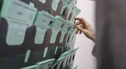 Una votante escoge la papeleta para elegir a su candidato hoy en el colegio electoral ubicado en la biblioteca de Sanlúcar de Barrameda(Cádiz).