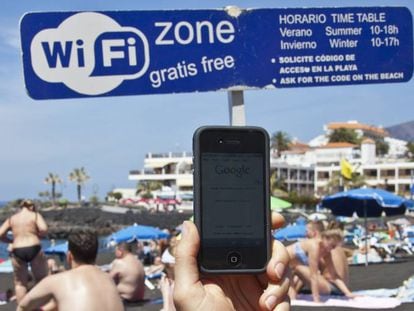 Un internauta se conecta a la red wifi gratuita de la playa de La Arena, en Tenerife.