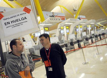 Dos trabajadores en una protesta de los tripulantes de cabina de Iberia en Barajas.