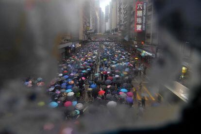 La ola de protestas empezó en junio contra un proyecto de ley que buscaba autorizar las extradiciones a China continental. En la imagen, miles de personas protestan bajo la lluvia por el centro de Hong Kong.