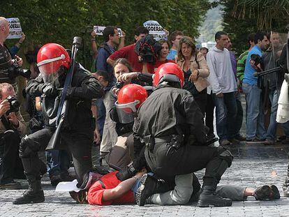 Varios <i>ertzainas</i> detienen a un joven durante los incidentes de San Sebastián.