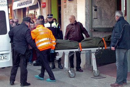 Trabajadores de los servicios sociales trasladan el cadáver de la mujer asesinada en Badajoz.