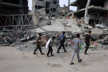 Un grupo de niños pasa junto a edificios destruidos en Rafah, en el sur de la Franja, este sábado. 