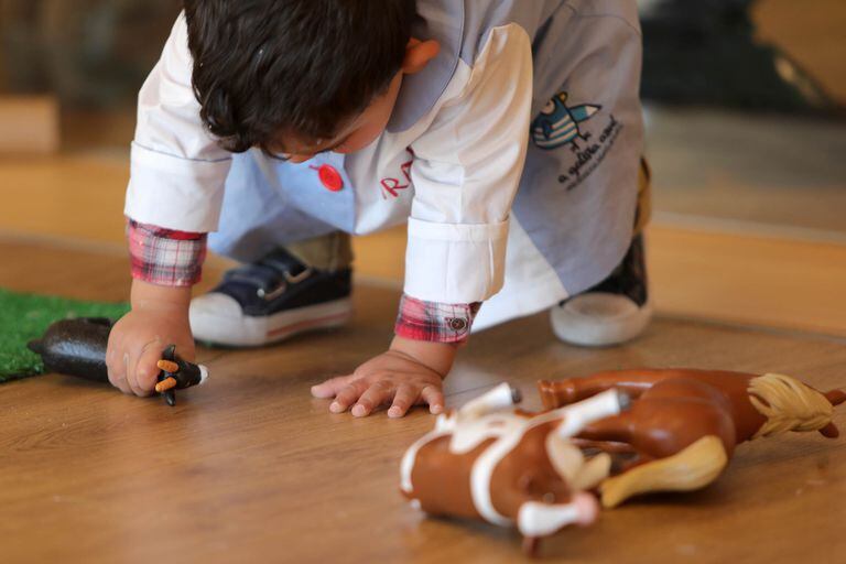 Un niño juega con muñecos.