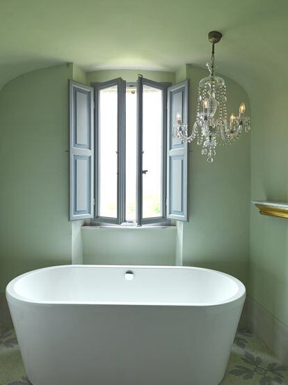 La bañera minimalista de Devon&Devon se complementa con la lámpara de lágrimas adquirida en un anticuario.