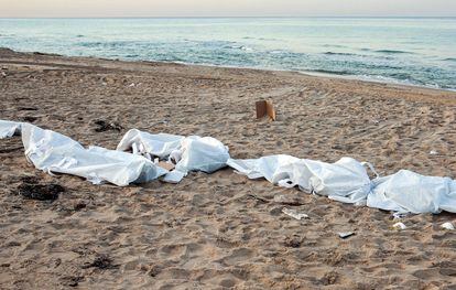 EDITORS NOTE: Graphic content / This picture taken on December 26, 2021 along a beach in Qasr Khiyar, about 70 kilometres east of Libya's capital, shows the bodies of migrants who were found ashore after drowning at sea. - The bodies of 28 migrants have washed up on Libya's western coast after their boat sunk, a security official said Sunday, the latest tragedy on the world's deadliest migration route. (Photo by Mahmud TURKIA / AFP)