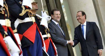 El presidente del Gobierno, Mariano Rajoy, saluda a François Hollande, en la puerta del Elíseo.