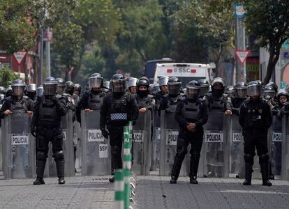 Policías con equipo antidisturbios se posicionan en una calle del Centro Histórico de la Ciudad de México.