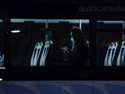 Un hombre consulta su teléfono móvil en el interior de un autobús, en Valladolid.