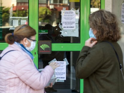 Clientas de Unicaja se encuentran las puertas de la sede de Málaga con carteles sobre la huelga.