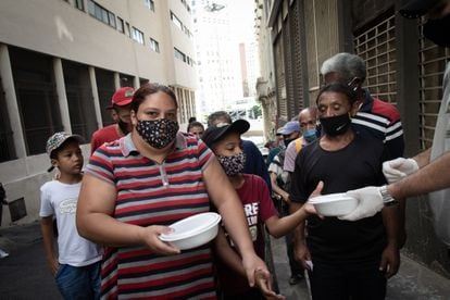 La pareja Maxwell Oliveira y Verônica Medeiros reciben la donación de alimentos en São Paulo.