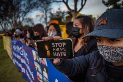 Una mujer sostiene un móvil con la frase "detengan el odio a los asiáticos" en una vigilia este miércoles, en California.