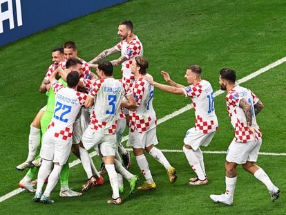 Los jugadores de Croacia abrazan a su portero Livakovic tras lograr la clasificación ante Japón.