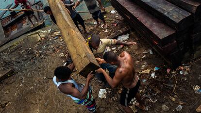 Trabajadores afrocolombianos cargan madera aserrada para ser exportada, en Turbo (Colombia), el 3 de diciembre de 2019.