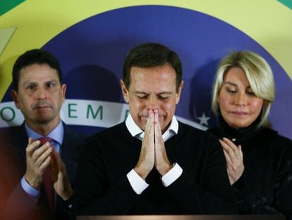 El exgobernador João Doria, tras anunciar su renuncia este lunes flanqueado por el presidente de su partido y por su esposa.