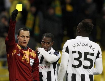 El árbitro le enseña la cartulina amarilla al jugador del Newcastle Massadio Haidara.