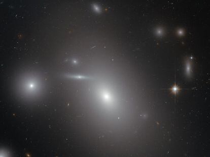 La galaxia elíptica NGC 4889, el objeto más brillante en el centro de la imagen, oculta un descomunal agujero negro en su interior