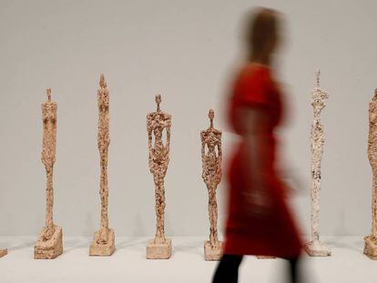 Una visitante pasea ante la serie de esculturas &#039;Mujer de Venecia&#039;, de Alberto Giacometti, en la Tate Modern de Londres.