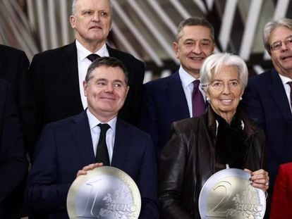 El presidente del Eurogrupo, Paschal Donohoe (sosteniendo una moneda de 1 euro), la presidenta del BCE, Christine Lagarde, y la vicepresidenta económica española Nadia Calviño, el lunes en Bruselas, con otros miembros del Eurogrupo.