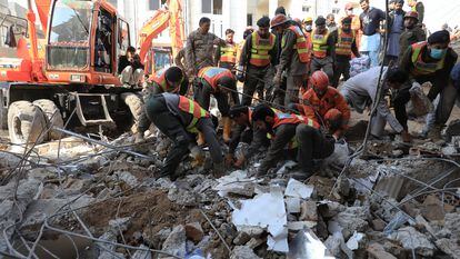 Miembros de los equipos de rescate retiran los escombros con las manos para buscar a posibles supervivientes del atentado de este 30 de enero en Peshawar.