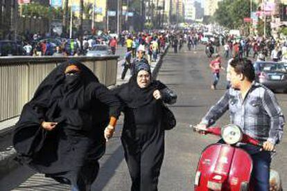 Dos mujeres egipcias contrarias al grupo "Los Hermanos Musulmanes", huyen de miembros de ese movimiento, durante unos disturbios entre miembros del grupo "Los Hermanos Musulmanes", ilegal en Egipto, y del movimiento "Bloque Negro", en El Cairo (Egipto). EFE/Archivo