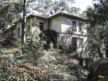 Una senderista frente al pabellón María Luisa Pelayo, también conocido como La Picota, en la isla de Pedrosa (Cantabria).