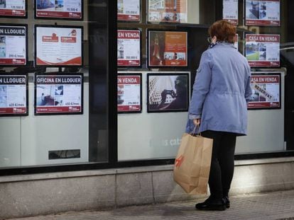 Una mujer mira el escaparate de una agencia inmobiliaria en Terrassa (Barcelona).