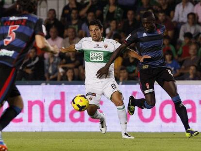 Nyom pelea un bal&oacute;n con Mantec&oacute;n, del Elche.  