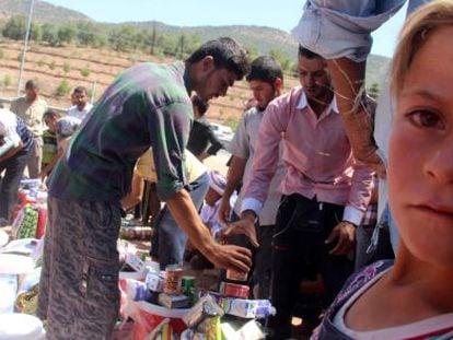 Integrantes del grupo religioso minoritario Yazidi hu&iacute;dos de Mosul reciben ayuda humanitaria en la ciudad de Dohuk.