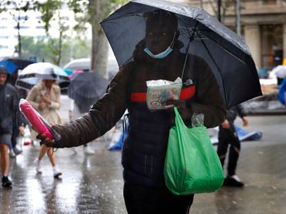 Un vendedor ambulante de paraguas, bajo la lluvia, el pasado 26 de abril en Barcelona.