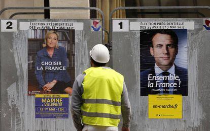 Un obrero observa los carteles de los candidatos a la segunda vuelta en Francia