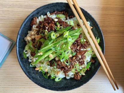 Un tazón de ramen con una cuchara y un par de palillos.