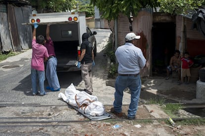 Familiares y miembros del equipo forense de medicina legal de San Salvador trasladan el cuerpo de un joven recientemente asesinado por las pandillas.