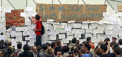 Jóvenes integrantes del Movimiento 15-M colocan mensajes en los paneles instalados en el <i>kilómetro cero</i> de la Puerta del Sol.