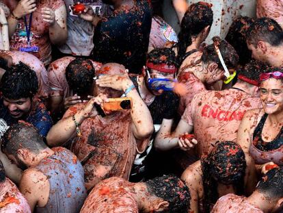 A man takes a photo in the midst of the crowds at Tomatina 2018.