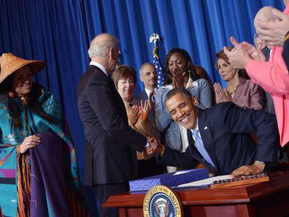 Barack Obama estrecha la mano de Joe Biden, tras firmar la Ley contra la Violencia contra las Mujeres.
