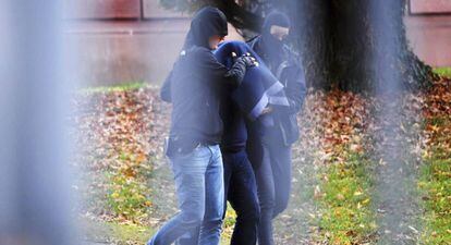 Polic&iacute;as escoltan en Hildesheim (Alemania) a uno de los cinco sospechoso detenidos el martes en una operaci&oacute;n contra el Estado Isl&aacute;mico. 