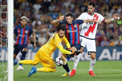 Robert Lewendowski lucha con el portero Stole Dimitrievski durante el partido entre el Barcelona y el Rayo Vallecano este sábado en el Camp Nou.