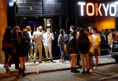 Varios grupos de jóvenes esperan en el exterior de un establecimiento durante la primera noche de la reapertura del ocio nocturno con restricciones en Vigo, el 1 de julio.