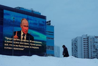 Una mujer camina este jueves en Moscú frente a una pantalla que muestra una cita de Vladímir Putin en su rueda de prensa anual. 