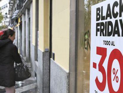 Un cliente pasa junto un escaparate con publicidad del Black Friday