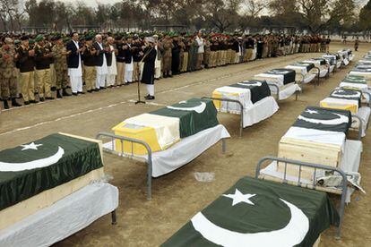 Militares y policías paquistaníes asisten al funeral de las víctimas del atentado suicida en la región de Peshawar.
